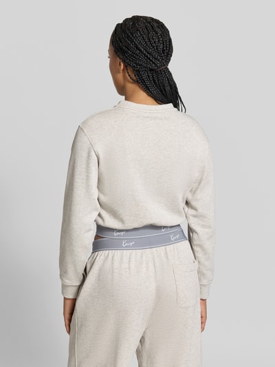 Frauenmodel trägt Cropped Sweatshirt mit Logo-Stitching von Kenzo in Beige mit elastischen Abschlüssen aus reiner Baumwolle, Rückenlänge 44 cm, Ganzkörperansicht Rückansicht.