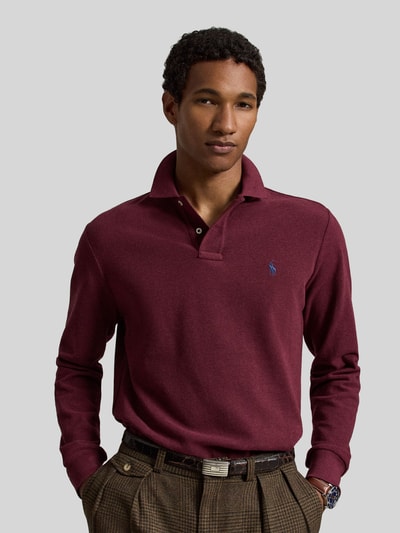 Männermodel trägt Regular Fit Poloshirt aus reiner Baumwolle von Polo Ralph Lauren in Bordeaux mit glatter Struktur, Nahaufnahme Oberkörper.