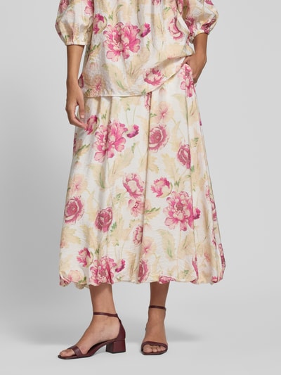 Frauenmodel trägt Midirock aus Viskose-Mix Modell 'Maise' von FREE/QUENT im Allover-Blumenmuster, A-Linie, zarte Farben, Nahaufnahme Unterkörper.