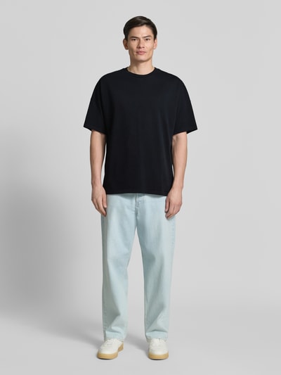 Männermodel trägt T-Shirt mit Rundhalsausschnitt Modell 'FIZVALLEY' von American Vintage, schwarze Baumwolle, Loose Fit, Ganzkörperansicht von vorne