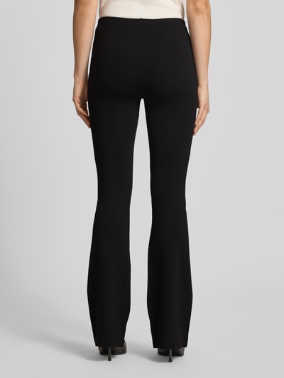 Kobiece modelka nosi czarne Flared Fit Stoffhose aus Viskose-Mix od Review, elastyczny materiał, szerokość w rozmiarze S: 37 cm, długość nogawki 85 cm, widok całej sylwetki od tyłu.