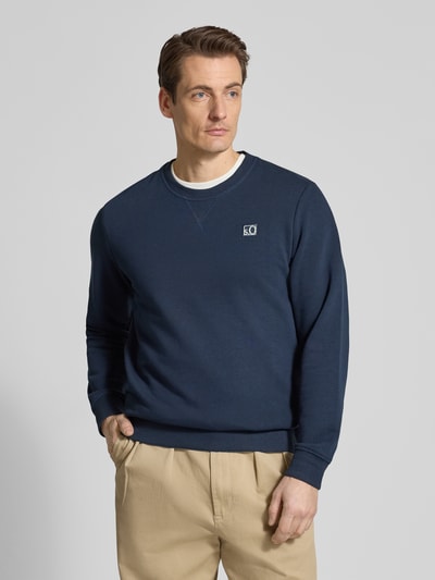Męski model nosi Regular Fit Sweatshirt aus Baumwoll-Mix von s.Oliver RED LABEL, jednolity kolor, okrągły dekolt, wyhaftowane logo, krój regular fit, długi rękaw, mieszanka bawełny, dzianina dresowa, całkowity widok z przodu