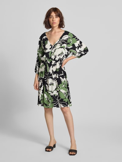Frauenmodel trägt knielanges Kleid aus Viskose im Allover-Look Modell 'Fe44li' von ZABAIONE in A-Linie, grün-schwarz-weiß, Ganzkörperansicht von vorne.