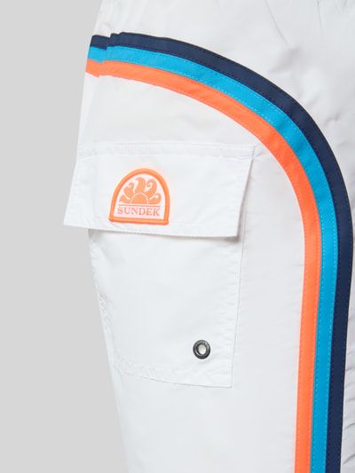 Produktfoto, Badehose mit elastischem Bund Modell 'UNI SHORTS NEON' von Sundek, weiß mit blauen und orangen Streifen, Nahaufnahme Oberkörper.