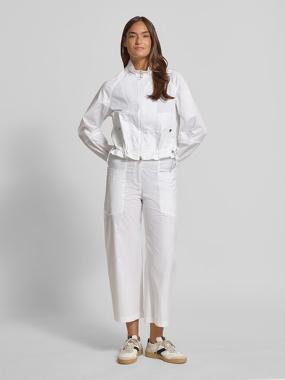 Frauenmodel trägt Wide Fit Stoffhose mit AufgesetzteTaschen von Marc Cain aus elastischem Baumwoll-Mix, verkürzte Passform, Ganzkörperansicht von vorne.