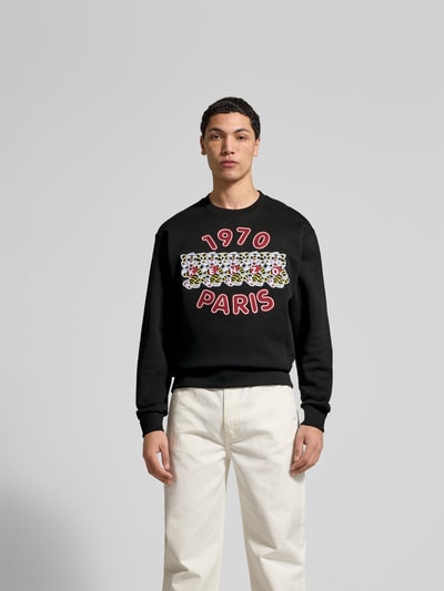 Männermodel trägt Sweatshirt aus reiner Baumwolle von Kenzo in Schwarz mit Label-Print und lockerer Passform, Ganzkörperansicht von vorne.