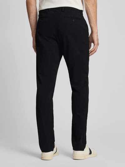 Männermodel trägt Slim Fit Chino mit Eingrifftaschen von GAP aus schwarzem Baumwoll-Elasthan-Mix, Ganzkörperansicht Rückansicht.