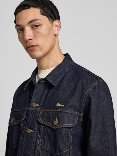 Mannelijk model draagt 'Jeansjacke mit Brusttaschen und Label-Stitching' van BLKVIS, donkerblauw, pure katoen, regular fit, knoopsluiting, borstzakken, label-stiksel, close-up bovenlichaam.