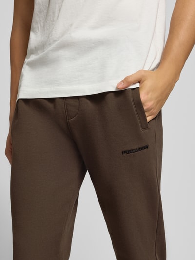 Männermodel trägt Sweatpants mit elastischem Bund von Pegador, Baumwoll-Mix, Label-Stitching, lockerer Schnitt, Nahaufnahme Oberkörper.