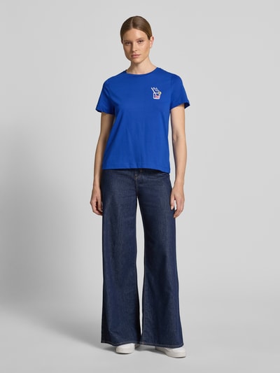 Frauenmodel trägt Regular Fit T-Shirt aus reiner Baumwolle von Tom Tailor in Blau, unifarben mit Motiv-Print und Rundhals, Ganzkörperansicht von vorne.