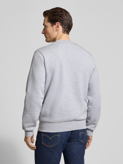 Męski model nosi Regular Fit Sweatshirt aus Baumwoll-Mix od Lacoste, jednolity kolor, naszywka z logo, prążkowane wykończenia, dzianina dresowa, mieszanka bawełny, widok całej sylwetki z tyłu.