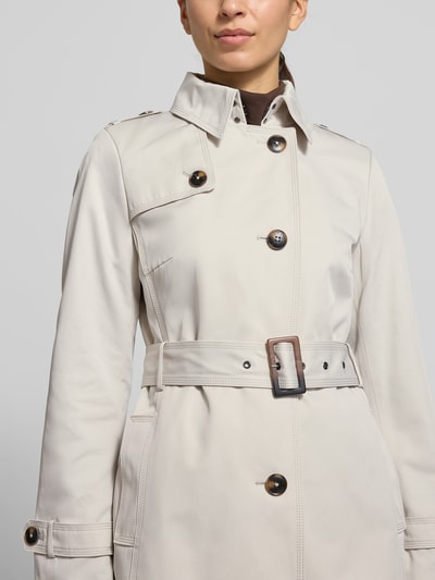 Frauenmodel trägt Mantel mit Stoffgürtel von Jake*s Casual in Beige, Umlegekragen, Knopfleiste, Eingrifftaschen, Nahaufnahme Oberkörper.