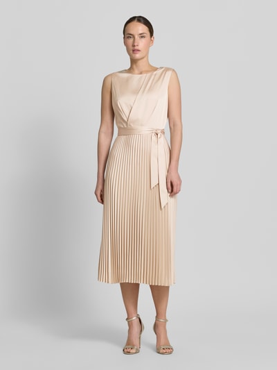 Kobiece model prezentuje Midikleid mit Plisseefalten und Bindegürtel von comma, mieszanka materiałów z dodatkiem streczu, linia a, plisy, wiązany pasek, długość tyłu w rozmiarze 36: 35 cm, szerokość w rozmiarze 36: 40 cm, jasny beż, struktura lekko błyszcząca i plisowana, widok całej sylwetki z przodu.