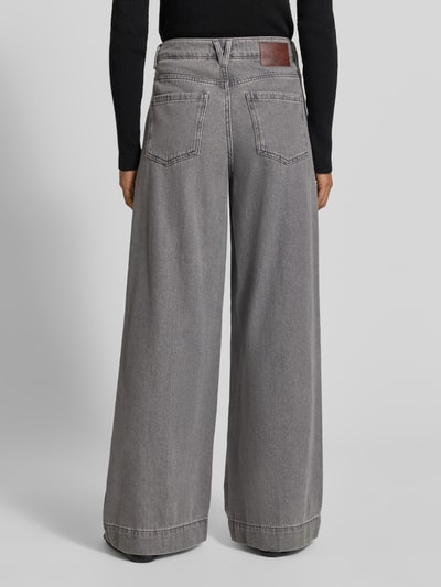 Frauenmodel trägt Wide Fit Jeans mit gelegten Falten von MYON aus reiner Baumwolle in Grau, sichtbare Teilungsnähte, Ganzkörperansicht Rückansicht.