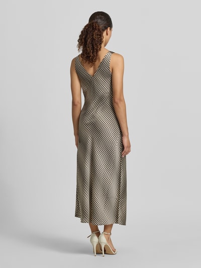 Frauenmodel trägt Midikleid mit V-Ausschnitt Modell 'Qova wave' von Someday in Satin, schwarz-beige Muster, Ganzkörperansicht Rückansicht.