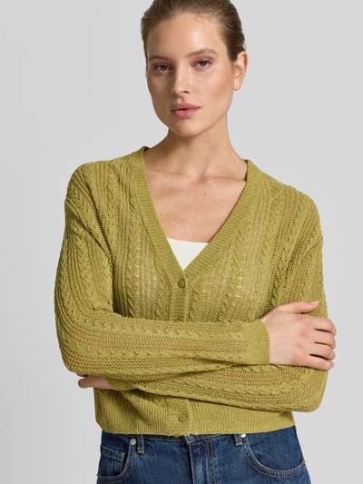 Frauenmodel trägt Strickjacke mit V-Ausschnitt Modell 'ROSI' von Mango, grün, Baumwoll-Mix, Regular Fit, Nahaufnahme Oberkörper.