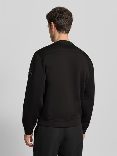 Männermodel trägt Sweatshirt mit Rundhalsausschnitt von Guess, Schwarz, Regular-Fit, Material-Mix mit Viskose-Anteil, Label-Patch, Rückenlänge 65 cm, Ärmellänge 67 cm, Ganzkörperansicht Rückansicht.