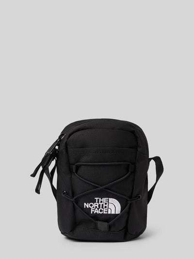 Produktfoto, schwarze Handtasche mit Label-Stitching von The North Face, Reißverschlussfächer, Schulterriemen, glatte Textur, kompakte Form.