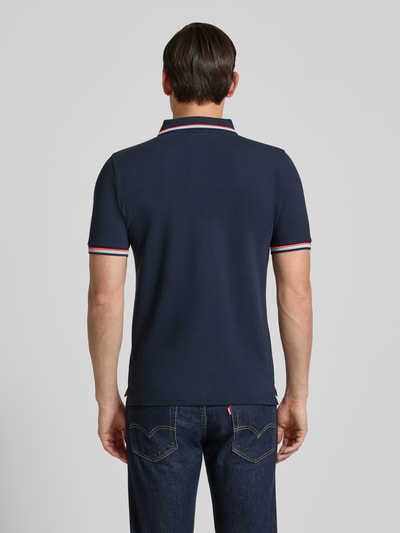 Męski model nosi ciemnogranatową koszulkę polo z mieszanki bawełny i elastanu Sundek, model 'Brice', krój slim fit, paski w kontrastowym kolorze, listwa guzikowa, długość tyłu w rozmiarze M: 70 cm. Ganzkörperansicht Rückansicht.