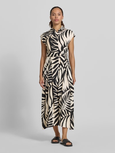 Frauenmodel trägt Hemdblusenkleid aus Viskose mit Bindegürtel Modell 'APPLE' von Mango, schwarz-beige gemustert, tailliert, Ganzkörperansicht von vorne.