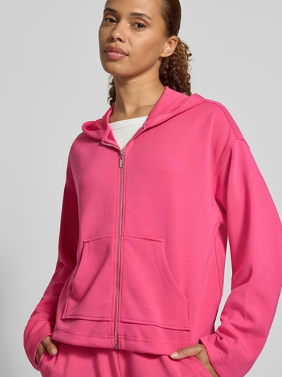 Frauenmodel trägt Regular Fit Sweatjacke mit Modal-Anteil von Christian Berg Woman in Pink, mit Kapuze, Reißverschluss, Känguru-Tasche, Elastik-Material-Mix, Ganzkörperansicht von vorne.