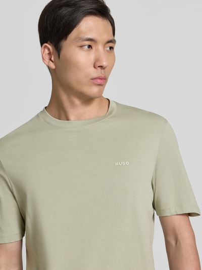 Männermodel trägt Regular Fit T-Shirt aus reiner Baumwolle Modell 'DERO222' von HUGO, Optik: Unifarben, Label-Print, Jersey, Nahaufnahme Oberkörper.