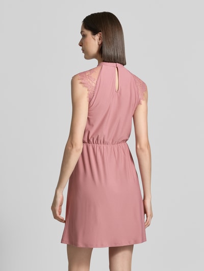Frauenmodel trägt Tailliertes Freizeitkleid mit Spitzenbesatz Modell 'MILLA' von Vero Moda, Optik: Unifarben, Mini-Länge, Hochgeschlossen, Kurzarm, Materialverarbeitung: Stretch, Ganzkörperansicht Rückansicht.
