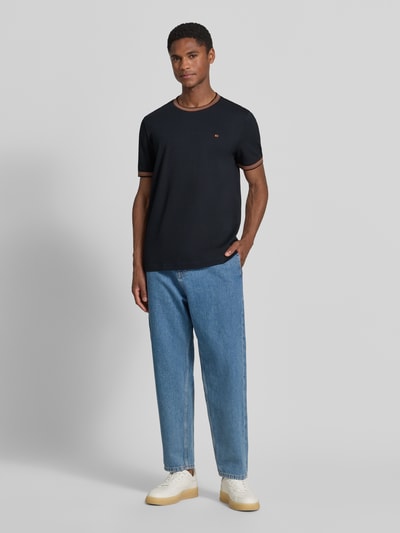 Męski model nosi Regular Fit T-Shirt mit Logo-Stitching von Christian Berg Men z bawełny, okrągły dekolt, długość tyłu 71 cm, Ganzkörperansicht von vorne.