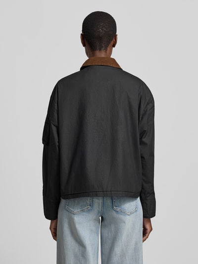 Männermodel trägt Jacke aus bawełny z kieszeniami z patką von Original Bombers, krój regular fit, wykładany kołnierz, listwa guzikowa, długość tyłu w rozmiarze S: 60 cm, szerokość ramion w rozmiarze S: 52 cm, szerokość klatki piersiowej w rozmiarze S: 58 cm, długość rękawów w rozmiarze S: 57 cm, czarna i brązowa, matowa tekstura, Ganzkörperansicht Rückansicht.
