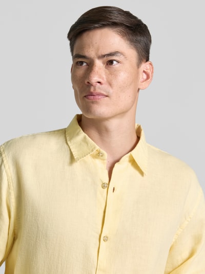 Männermodel trägt Regular Fit Leinenhemd mit Kentkragen von GAP in sanftem Gelb, sichtbare Knopfleiste, Nahaufnahme Oberkörper, Kontext: Herren Leinenhemd, reine Leinen, Regular-Fit, Kentkragen, Knopfleiste, Rückenlänge bei Größe M 71 cm, Schulterbreite bei Größe M 49 cm, Ärmellänge bei Größe M 64 cm