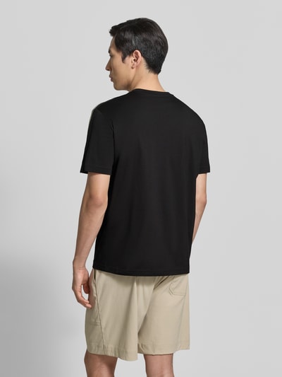 Męski model nosi Regular Fit T-Shirt mit Logo-Patch od EA7 Emporio Armani z bawełny, okrągły dekolt, długość tyłu 52 cm, Ganzkörperansicht Rückansicht.