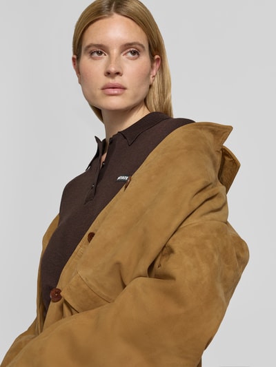 Frauenmodel trägt Blazer aus echtem Ziegenvelours von ROTATE in Camel, glatte Textur, Knopfleiste, Reverskragen, Nahaufnahme Oberkörper.