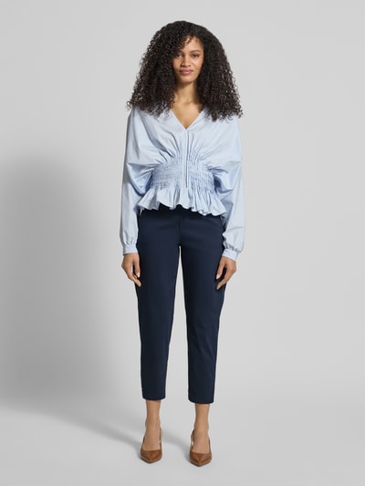 Frauenmodel trägt Straight Fit Stoffhose mit Eingrifftaschen Modell 'Ornela' von STEHMANN aus elastischem Baumwoll-Mix, verkürzte Passform, dunkelblau, Ganzkörperansicht von vorne.