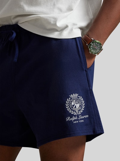Männermodel trägt dunkelblaue Regular Fit Sweatshorts aus reiner Baumwolle von Polo Ralph Lauren, Label Stitching, Nahaufnahme Oberschenkel.