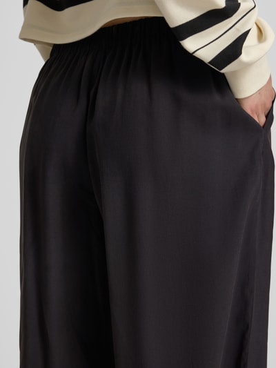 Frauenmodel trägt Loose Fit Weite Hose mit elastischem Bund Modell 'SCARLY' von Only, unifarben, Nahaufnahme Rückansicht.