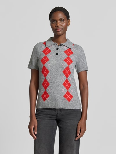 Frauenmodel trägt Slim Fit Poloshirt mit Woll-Anteil Modell 'Dasila' von ICHI in Grau mit roten Rauten, Strick-Optik, Nahaufnahme Oberkörper.