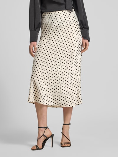 Vrouwenmodel draagt midirok met zwarte stippen, materiaalmix met stretch, model 'PELLA' van YAS, straight fit, naadritssluiting, totale lengte 85 cm, bandwijdte maat S 37 cm, close-up onderlichaam.