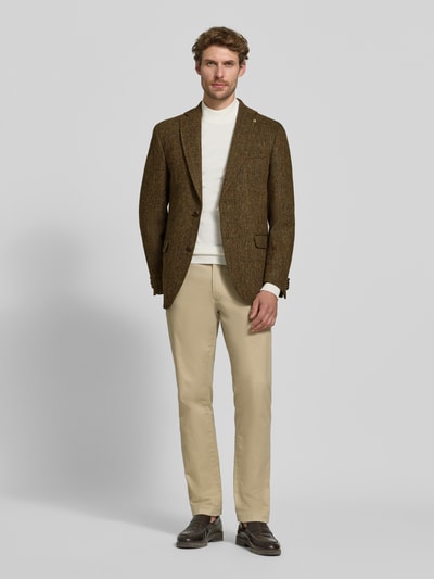 Męski model nosi Slim Fit 2-Knopf-Sakko mit Pattentaschen Modell 'Theo' von Carl Gross z czystej żywej wełny w kolorach brązowym i beżowym, Kołnierz z połami, kieszenie z patką, długość tyłu w rozmiarze 50: 75 cm, szerokość ramion w rozmiarze 50: 44 cm, długość rękawów w rozmiarze 50: 66 cm, Ganzkörperansicht von vorne.