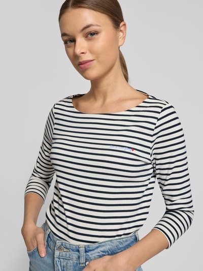 Vrouwenmodel draagt Regular Fit 3/4-Shirt uit katoenmix van Tom Tailor met allover-streeppatroon en kleine print, nahaufnahme bovenlichaam.