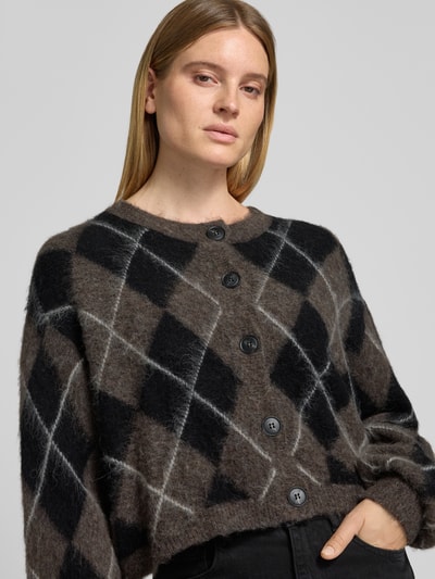 Frauenmodel trägt Relaxed Fit Cardigan aus Woll-Mix Modell 'sida' von Gestuz im Allover-Look, braun-schwarz gemustert, Nahaufnahme Oberkörper.