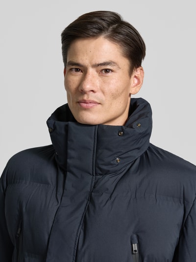 Männermodel trägt Regular Fit Steppmantel mit abnehmbaren Kapuze Modell 'Ambience' von Strellson, Herren Steppmantel, Nahaufnahme Oberkörper.