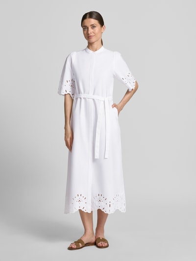 Frauenmodel trägt Hemdblusenkleid mit Lochstickerei Modell 'Marika' von GUIDO MARIA KRETSCHMER WOMAN in Weiß, Reine Baumwolle, Taillierter Schnitt, Midikleid, Maokragen, verdeckte Knopfleiste, Bindegürtel, Textur durch Stickerei, Ganzkörperansicht von vorne.