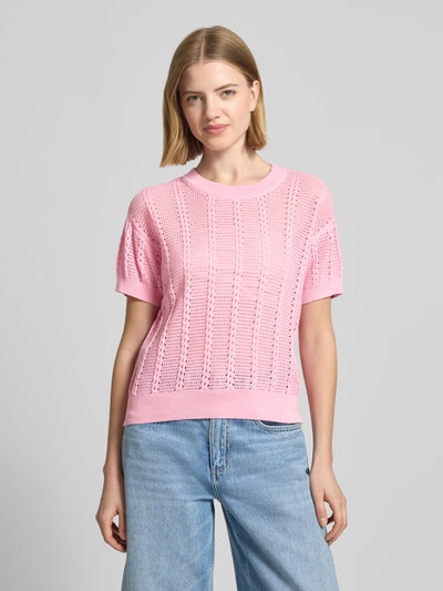 Kobiece model nosi Relaxed Fit Strick-Shirt aus Baumwoll-Mix Modell 'LUX LIGHT' von Vero Moda, efekt: jednolity kolor, ażurowy wzór, okrągły dekolt, krótki rękaw, prążkowane zakończenia, mieszanka bawełny, dzianina ażurowa, jasnoróżowy, tekstura przewiewna, gładkie wykończenia, widok całej sylwetki z przodu.
