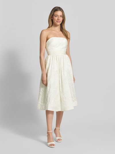 Frauenmodel trägt Minikleid mit floralem Allover-Stitching von Hey Kyla, taillierte und ausgestellte Passform, schulterfrei, Ganzkörperansicht von vorne.