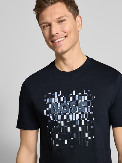 Männermodel trägt Regular Fit T-Shirt aus reiner Baumwolle Modell 'THOMPSON' von BOSS, Optik: unifarben, Label-Print, Rundhals, Kurzarm; Nahaufnahme Oberkörper.