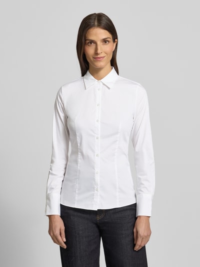 Frauenmodel trägt Hemdbluse mit 3-Knopf-Manschetten Modell 'The Fitted' von HUGO, Baumwollmischung mit Stretch-Anteil, taillierter Schnitt, Umlegekragen, Knopfleiste, Ganzkörperansicht von vorne.