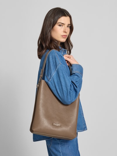Vrouwenmodel draagt schoudertas uit echt rundleer van Marc O'Polo, effen kleuren, magneetsluiting, labelpatch, rechthoekig, genarft leer. Ganzkörperansicht van voren.
