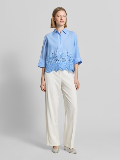 Frauenmodel trägt Boxy Fit Bluse mit Lochstickerei von Emily Van den Bergh aus Reine Baumwolle, Hellblau, Hemdblusenkragen, Knopfleiste, Ganzkörperansicht von vorne.