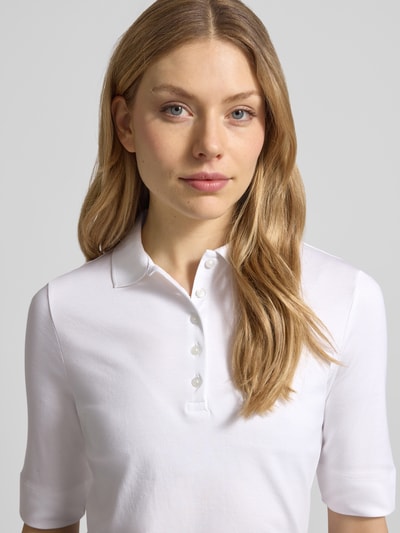 Vrouwenmodel draagt slim fit poloshirt met knoopsluiting en 1/2-mouwen van puur katoen, Christian Berg Woman, nahaufnahme bovenlichaam.