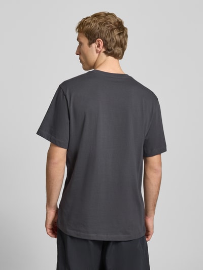 Männermodel trägt T-Shirt mit Logo-Stitching von The North Face aus Reine Baumwolle, Gerader-Schnitt, Rückenlänge 70 cm, Ganzkörperansicht Rückansicht.
